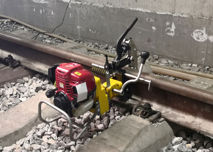 Rail drilling machine mounted beside a track