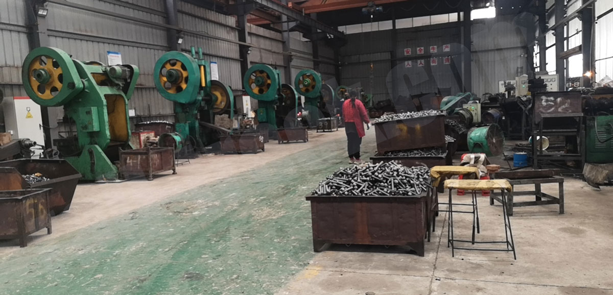 Track bolt forging line with bins of forged bolts